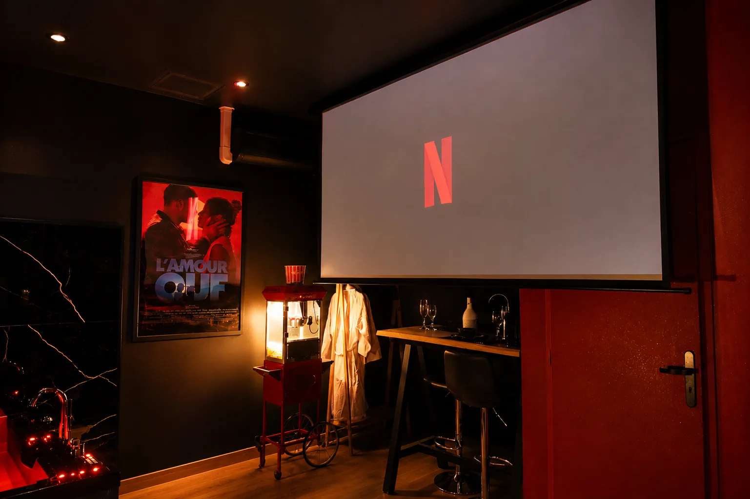 Écran cinéma, machine à pop-corn et coin bar de la Cinéma Room
